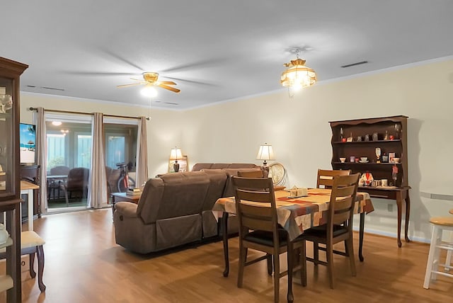 dining area featuring light hardwood / wood-style floors, crown molding, and ceiling fan