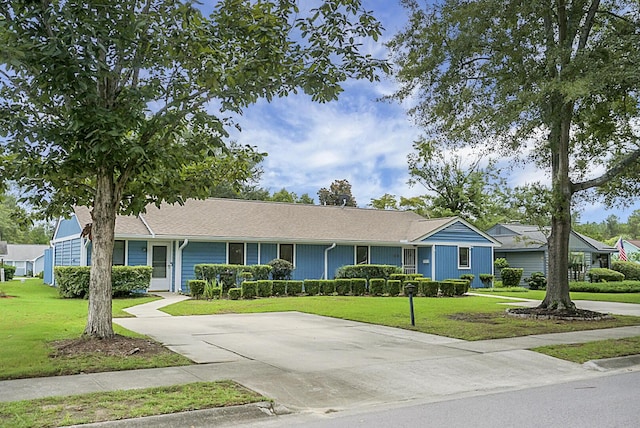 ranch-style house featuring a front yard and concrete driveway