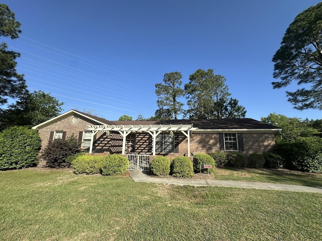 ranch-style house with brick siding, a front yard, and a pergola