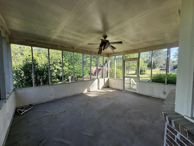 unfurnished sunroom with a ceiling fan and a wealth of natural light