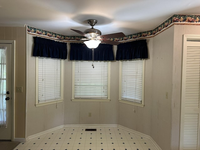 spare room with a ceiling fan, baseboards, and light floors