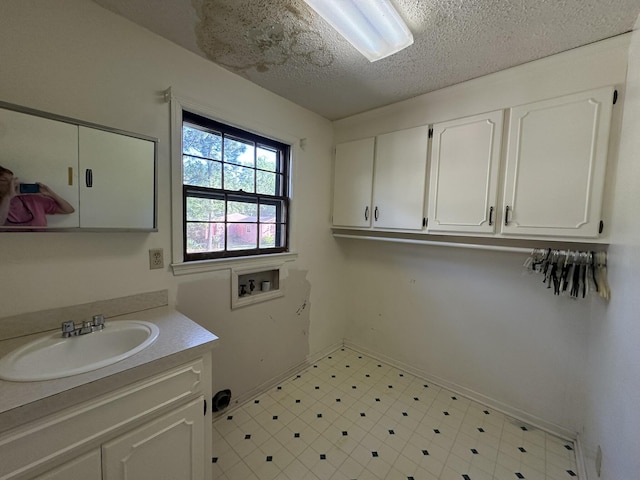 bathroom featuring baseboards, a textured ceiling, tile patterned floors, and vanity