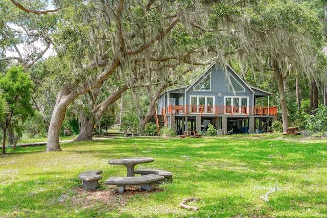 back of house with a wooden deck and a yard