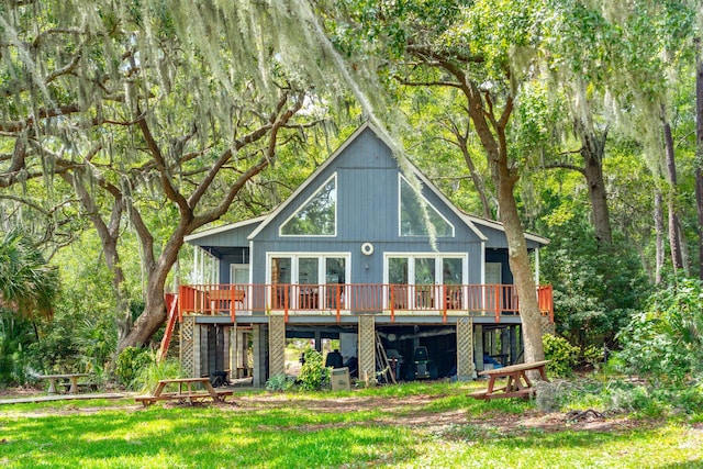 back of house with a deck and a yard