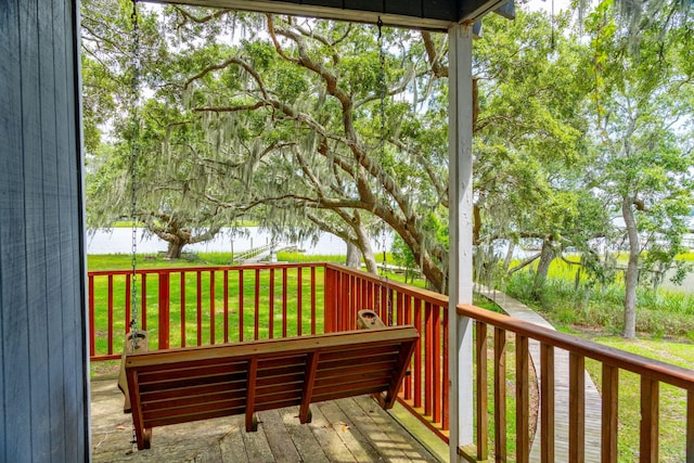 wooden deck featuring a lawn and a water view