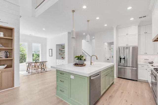 7053 Schooner St, Daniel Island, SC 29492 - kitchen featuring stainless steel appliances, green cabinetry, a sink, white cabinetry, and light wood-type flooring