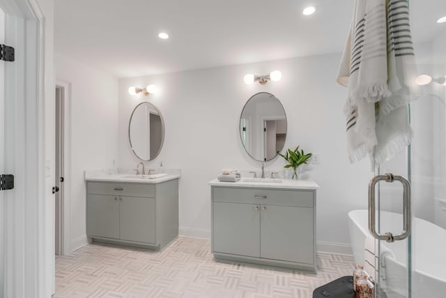 7053 Schooner St, Daniel Island, SC 29492 - full bathroom featuring two vanities, a freestanding bath, baseboards, and recessed lighting