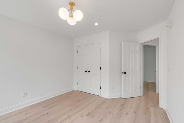 7053 Schooner St, Daniel Island, SC 29492 - unfurnished bedroom with light wood finished floors, baseboards, a closet, recessed lighting, and a chandelier