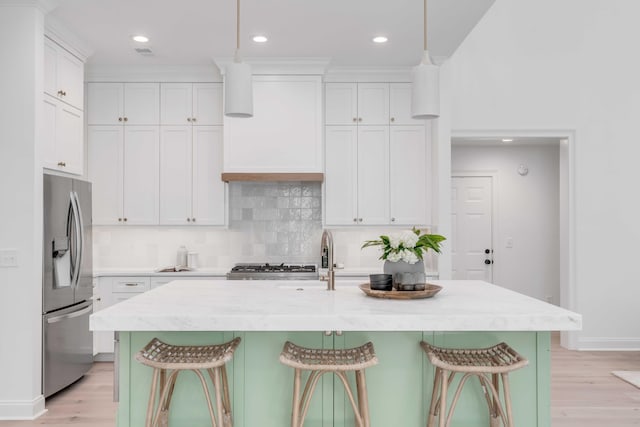 7053 Schooner St, Daniel Island, SC 29492 - kitchen featuring stainless steel fridge, light wood-style floors, tasteful backsplash, a sink, and recessed lighting