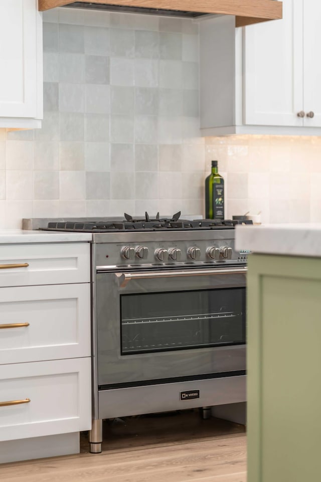 7053 Schooner St, Daniel Island, SC 29492 - kitchen featuring high end stainless steel range, white cabinets, backsplash, and light wood finished floors