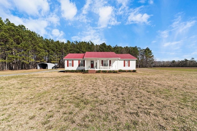 view of front of house featuring metal roof, a porch, and a front yard