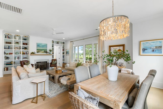 3023 Eventide Dr, Johns Island, SC 29455 - dining space with light wood-type flooring, ceiling fan, a chandelier, a fireplace, and recessed lighting