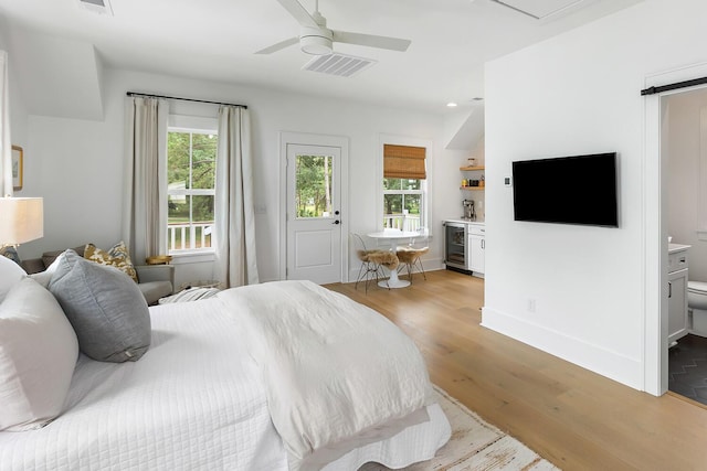 3023 Eventide Dr, Johns Island, SC 29455 - bedroom with wine cooler, light wood-type flooring, multiple windows, ensuite bathroom, and recessed lighting