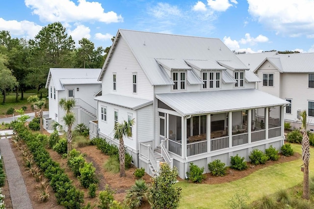 3023 Eventide Dr, Johns Island, SC 29455 - rear view of house with a sunroom, metal roof, and a lawn