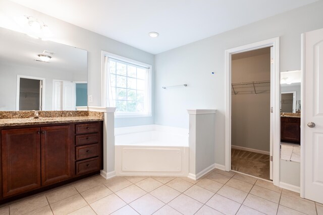 7217 Mossy Creek Ln, Hanahan, SC 29410 - bathroom featuring vanity, a walk in closet, a garden tub, tile patterned floors, and baseboards