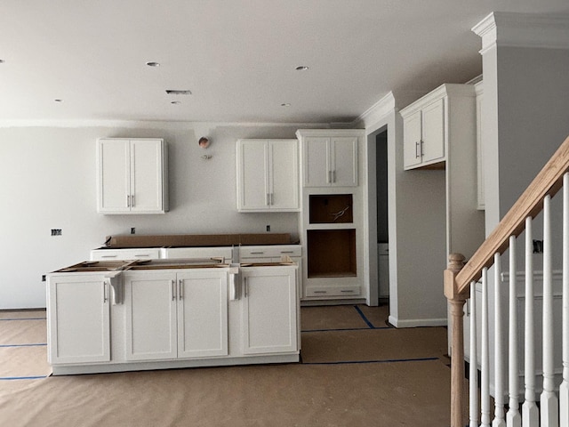 kitchen with ornamental molding, white cabinetry, and a center island