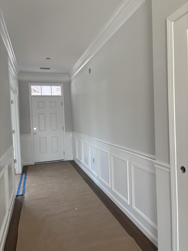 foyer with a wainscoted wall, dark wood-style floors, and crown molding