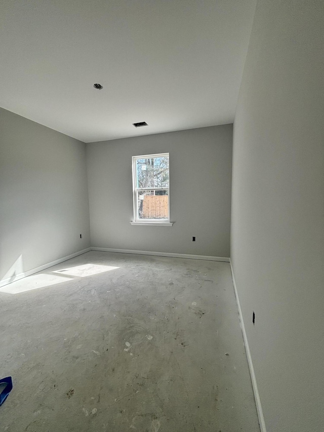 spare room with visible vents, unfinished concrete flooring, and baseboards