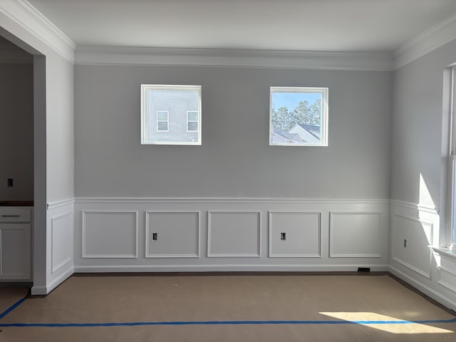 empty room featuring ornamental molding and wainscoting