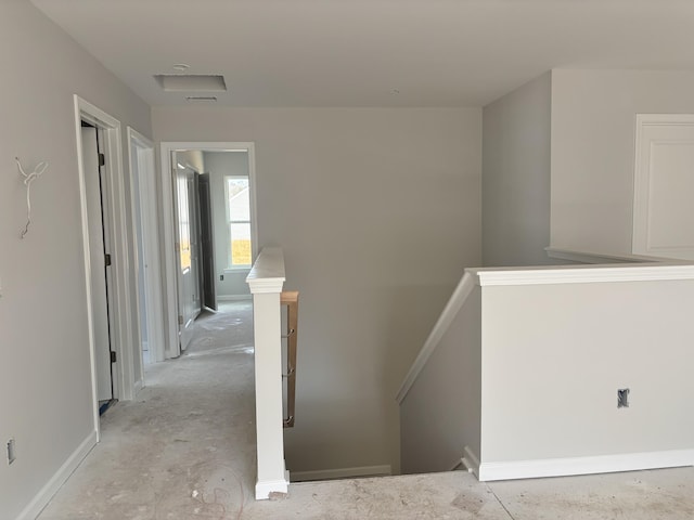 corridor featuring an upstairs landing and baseboards