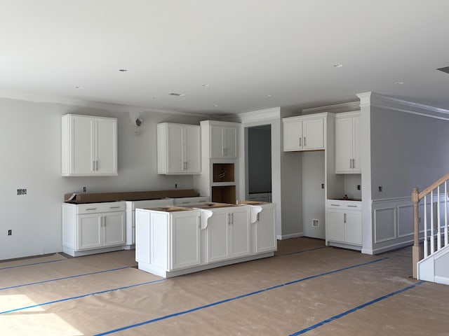 kitchen featuring white cabinets, crown molding, and a center island