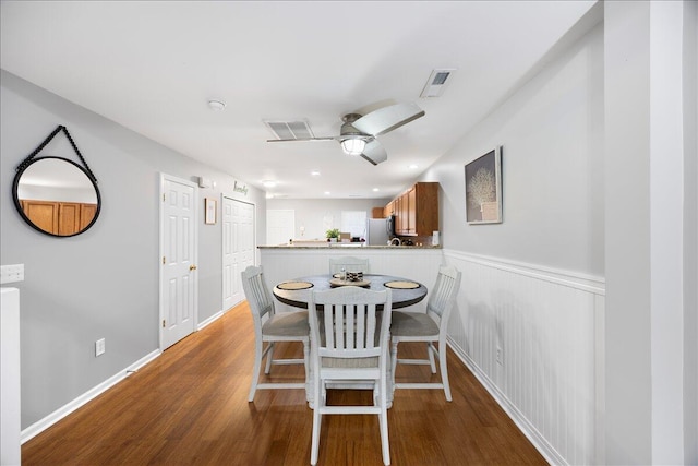 dining area with a ceiling fan, wood finished floors, visible vents, and baseboards