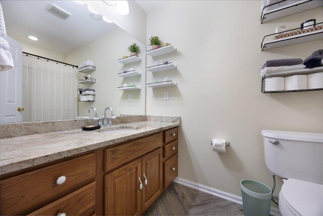 bathroom with visible vents, baseboards, toilet, and vanity