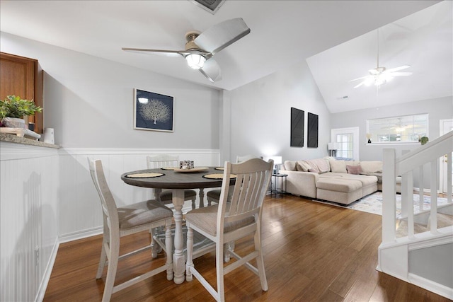 dining area featuring a wainscoted wall, lofted ceiling, a ceiling fan, and wood finished floors