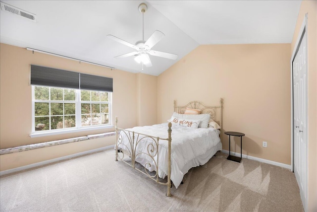 carpeted bedroom featuring a ceiling fan, baseboards, visible vents, lofted ceiling, and a closet