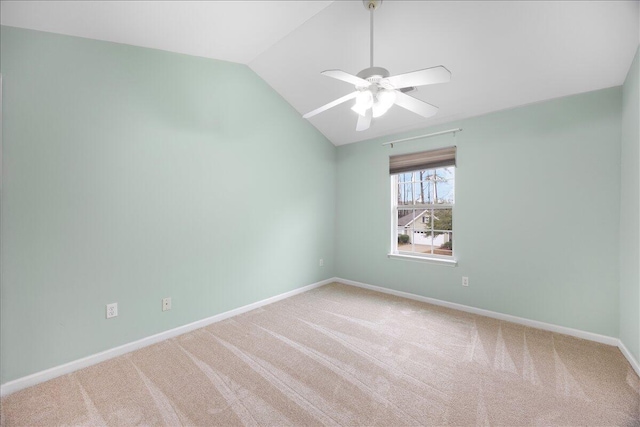 spare room with carpet flooring, baseboards, lofted ceiling, and a ceiling fan