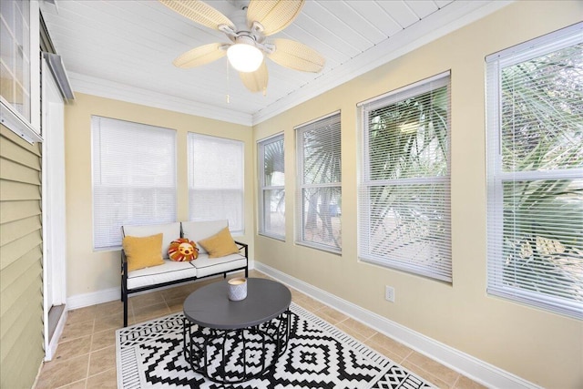 living area with light tile patterned floors, a ceiling fan, crown molding, and baseboards