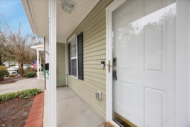 view of exterior entry featuring covered porch