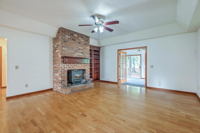 1023 Striper Ave, Moncks Corner, SC 29461 - unfurnished living room with a wood stove, ceiling fan, wood finished floors, and baseboards