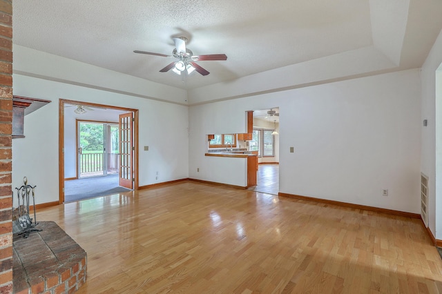 1023 Striper Ave, Moncks Corner, SC 29461 - unfurnished living room with ceiling fan, light wood-type flooring, baseboards, and a textured ceiling