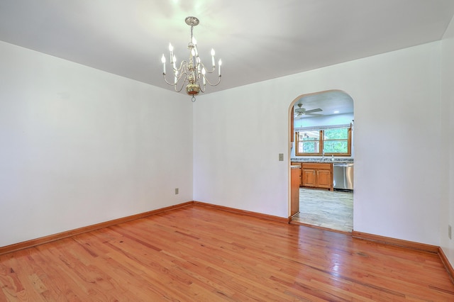 1023 Striper Ave, Moncks Corner, SC 29461 - spare room featuring light wood-type flooring, a chandelier, arched walkways, and baseboards