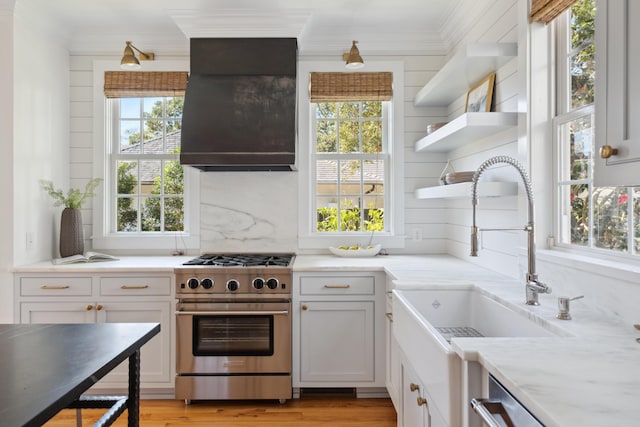 kitchen with range hood, appliances with stainless steel finishes, ornamental molding, and a sink