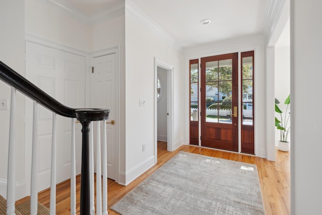 entrance foyer featuring stairs, crown molding, light wood-style floors, and baseboards