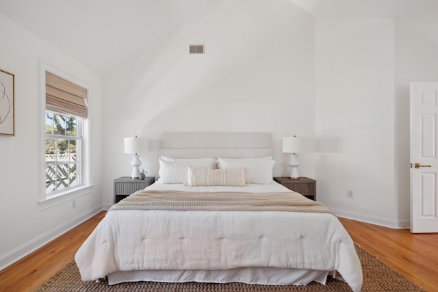 bedroom featuring wood finished floors, visible vents, and baseboards