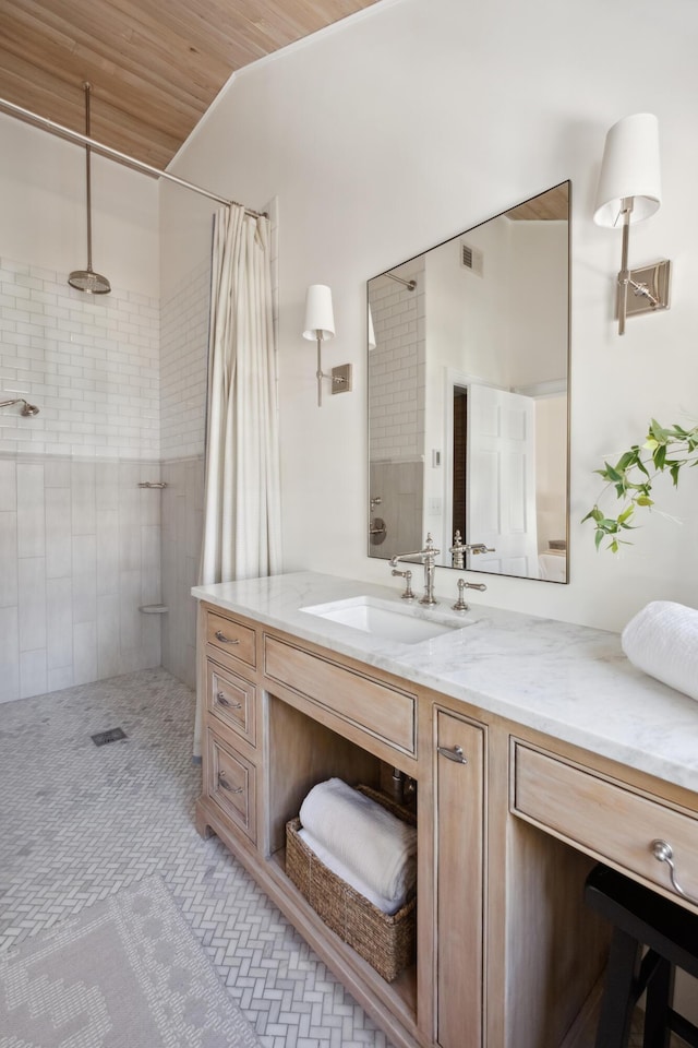 bathroom featuring vanity, visible vents, and a tile shower