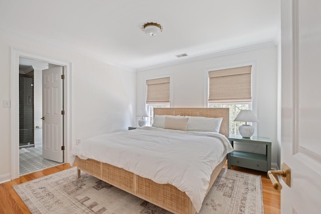 bedroom with visible vents, light wood-style floors, and ornamental molding