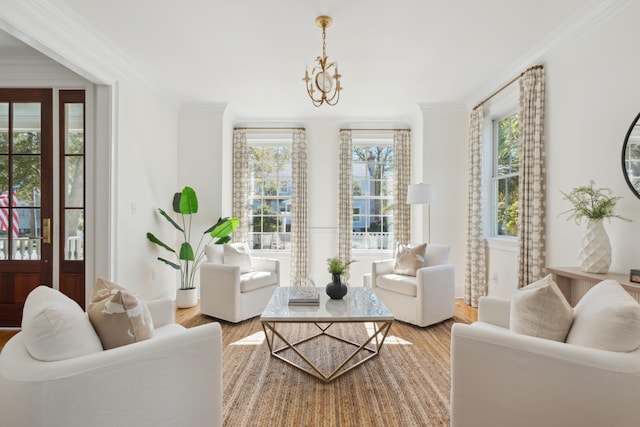 living area featuring a chandelier, ornamental molding, and wood finished floors