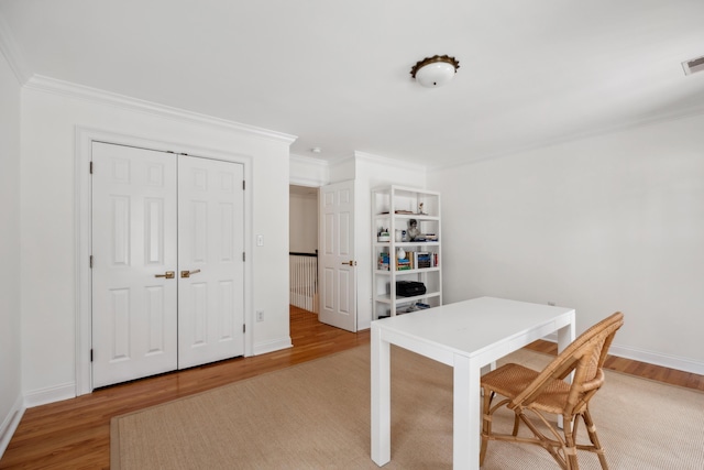 home office featuring baseboards, light wood-style floors, and ornamental molding