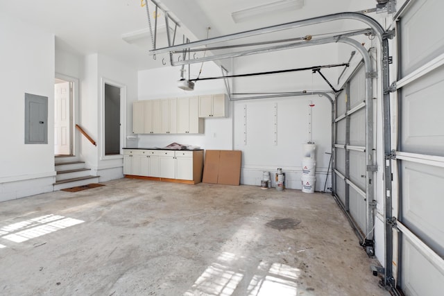 garage featuring electric panel, a garage door opener, and water heater