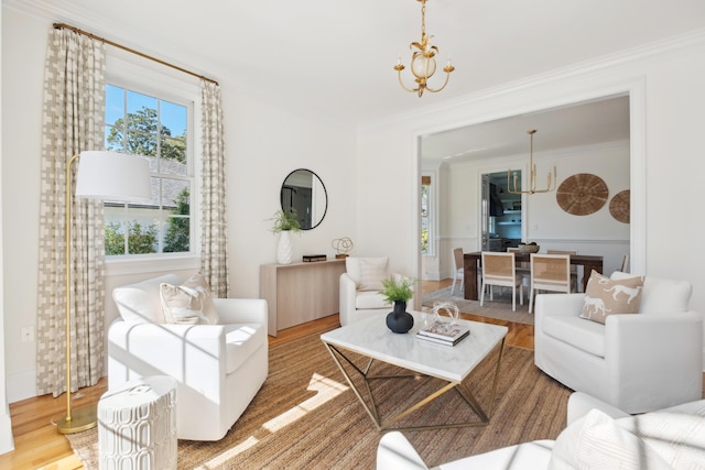 living room with an inviting chandelier, crown molding, and wood finished floors