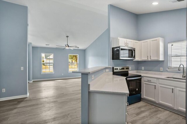 426 Colony Dr, Ridgeland, SC 29936 - kitchen featuring sink, kitchen peninsula, light hardwood / wood-style flooring, black / electric stove, and white cabinetry