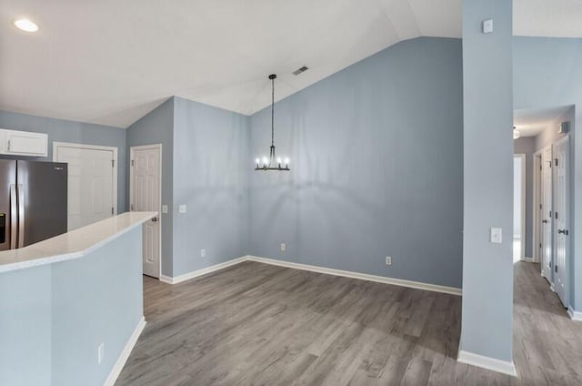 426 Colony Dr, Ridgeland, SC 29936 - kitchen featuring stainless steel fridge with ice dispenser, pendant lighting, vaulted ceiling, wood-type flooring, and white cabinets