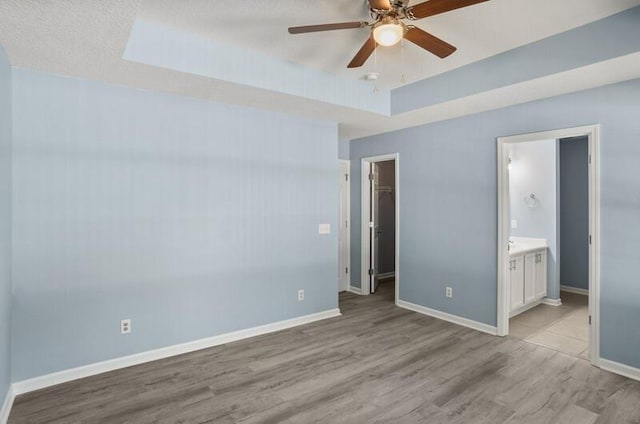 426 Colony Dr, Ridgeland, SC 29936 - unfurnished bedroom with a walk in closet, ensuite bathroom, ceiling fan, and light hardwood / wood-style floors