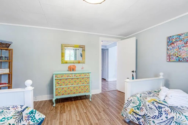 bedroom with light wood-type flooring and ornamental molding