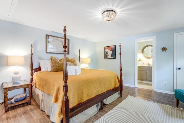 bedroom featuring hardwood / wood-style floors, sink, and ensuite bath