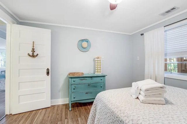 bedroom featuring light hardwood / wood-style floors, ceiling fan, and crown molding